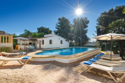 una piscina con tumbonas y sombrilla en Casa Virginia, en Jávea