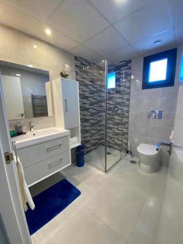 a bathroom with a shower and a toilet and a sink at Infinity View SNB in Arenales del Sol