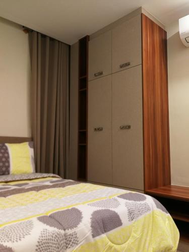 a bedroom with a bed and a dresser at Adria Residences - Ruby Garden - 2 Bedroom for 4 person in Manila
