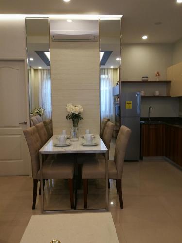 a dining room table with chairs and a vase of flowers on it at Adria Residences - Ruby Garden - 2 Bedroom for 4 person in Manila