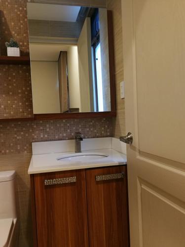a bathroom with a sink and a mirror at Adria Residences - Ruby Garden - 2 Bedroom for 4 person in Manila