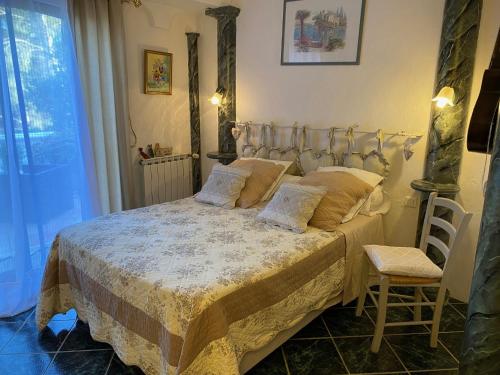 a bedroom with a bed and a chair and a window at La Florentine in Bandol