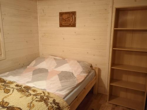 a bedroom with a bed in a room with shelves at Ranczo Rykowisko in Kołodzieje