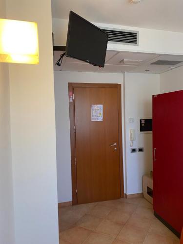 a room with a door and a television on the ceiling at Bed & Bike in Volterra