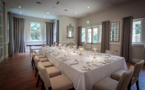 a large dining room with a long table and chairs at The Dower House Hotel in Woodhall Spa