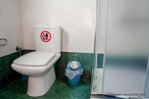 a bathroom with a toilet with a sign on it at marietta city center apartments Nafplio in Nafplio