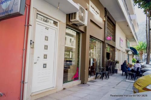 a street with tables and chairs outside of a store at marietta city center apartments Nafplio in Nafplio