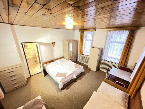 duży pokój z 2 łóżkami i 2 oknami w obiekcie Zlatá vyhlídka w mieście Benecko