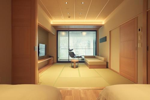 a bedroom with a bed and a desk and a window at Sansuiso Tsuchiyu Spa in Fukushima