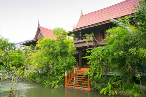 um edifício com um rio em frente em Ruennakornin Homestay em Ban Bang Kho