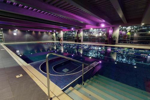 a swimming pool with purple lights in a building at Village Hotel Leeds South in Leeds