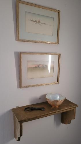 a wooden shelf with a bowl and a picture on the wall at Tofvehults Boende in Skaftet