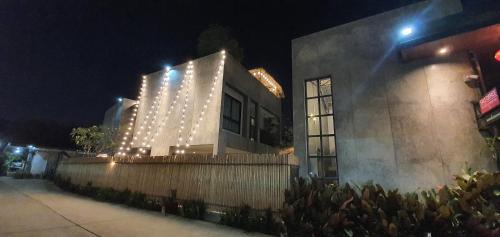 a building with lights on the side of it at night at Villa by the Win Pattaya in Jomtien Beach