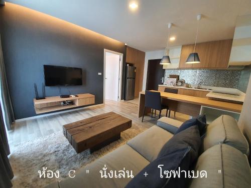 a living room with a couch and a table at Villa by the Win Pattaya in Jomtien Beach