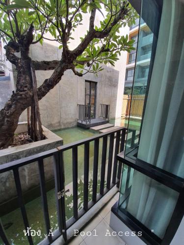 a balcony with a tree in a building at Villa by the Win Pattaya in Jomtien Beach