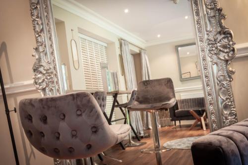 a room with a mirror and chairs and a piano at The Dower House Hotel in Woodhall Spa
