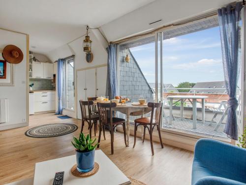 - un salon avec une table, des chaises et une grande fenêtre dans l'établissement Duplex face à la mer - Le Studio d'Adal, à Quiberon