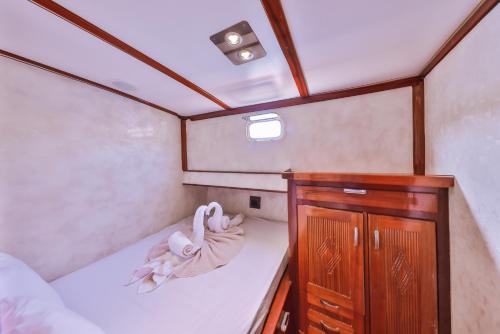 a small room with a bed and a wooden cabinet at Blue Cruise in Kas