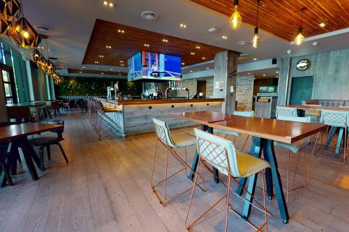 a bar with wooden tables and chairs in a restaurant at Village Hotel Leeds South in Leeds