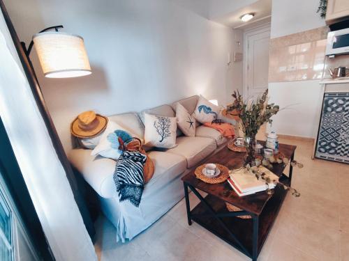 a living room with a couch and a table at APARTAMENTO FRENTE AL MAR CON PRECIOSAS VISTAS in Mazagón