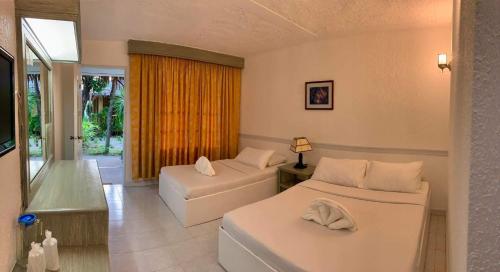 a hotel room with two beds and a window at Casa Pilar Beach Resort in Boracay
