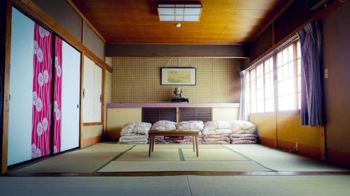 una sala de estar con una mesa en el centro de una habitación en NOZARU ONSEN HOSTEL, en Yamanouchi