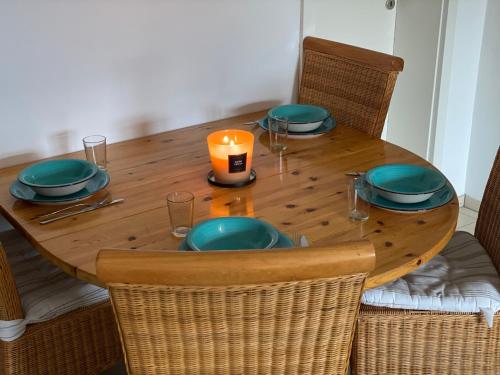 a wooden table with plates and a candle on it at Gemütliche Ferienwohnung auf dem Land in Bockenau