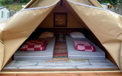 a couple of beds in a tent at Camping Lac de Villefort in Villefort