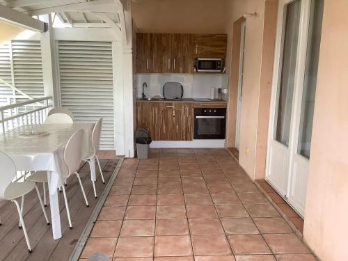 a kitchen and dining room with a table and chairs at VILLA ALIZEE APPARTEMENT N°6 in Sainte-Rose