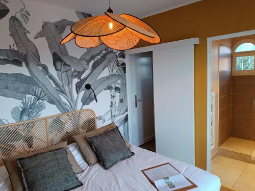 a bedroom with a bed with a plant mural on the wall at Les Galets Hôtel et B&B in Bandol