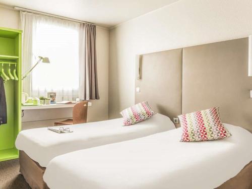 Habitación de hotel con 2 camas y ventana en Campanile Valence Sud, en Valence