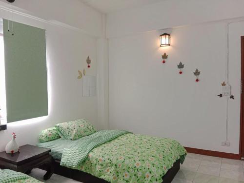 a bedroom with a bed with a green comforter at Free 1 set breakfast if book 48h before check in time2 No dog pls No breakfast on Sunday 10min taxi Airport train 2min walk 7-11 in Bangkok