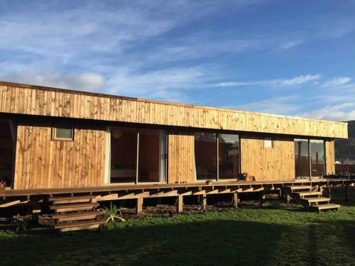 a large wooden building with a lot of windows at Surf and Stay Chile in Navidad