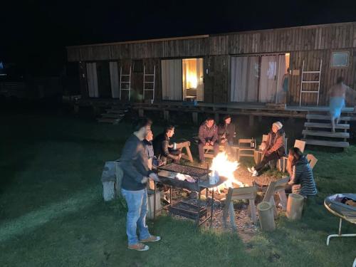a group of people standing around a fire at Surf and Stay Chile in Navidad