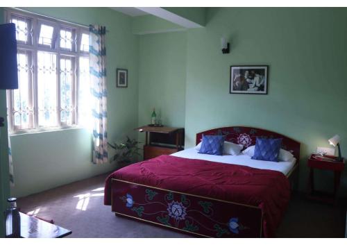 um quarto com uma cama com lençóis roxos e uma janela em Dazzle Homestay em Gangtok