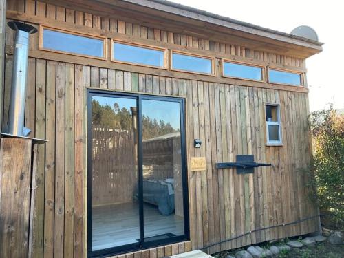 a wooden building with a glass door on it at Surf and Stay Chile in Navidad