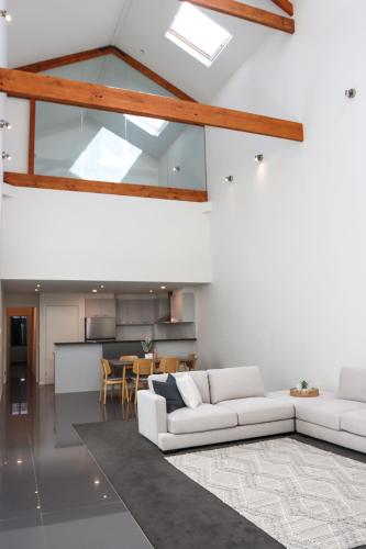 a living room with two white couches and a kitchen at Bendigo Townhouse - Walk to the CBD in Bendigo