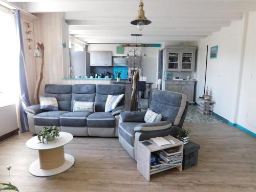 a living room with a blue couch and a table at MAISON MER LA NOE in Saint-Cast-le-Guildo