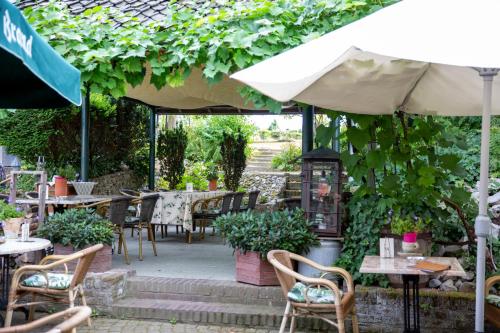 a patio with tables and chairs and an umbrella at Hotel De Oude Brouwerij in Mechelen