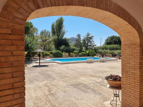um arco de tijolos que leva a uma piscina em El Rulón, gran villa rural con piscina privada em Alicante