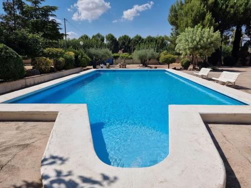 a swimming pool with blue water in a yard at El Rulón, gran villa rural con piscina privada in Alicante