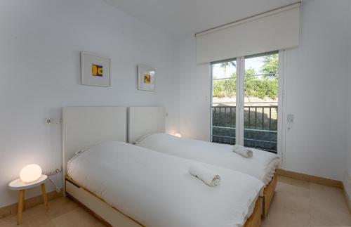 - une chambre avec 2 lits et une fenêtre dans l'établissement Los Eucaliptos Appartement deux chambres Chez Stefan, à Benahavís