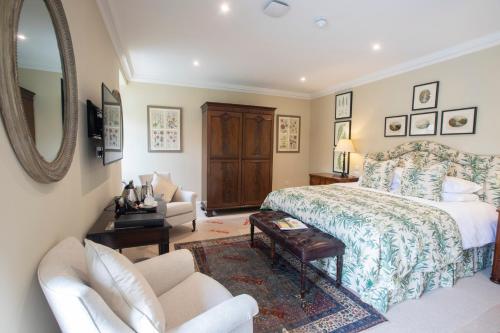 a bedroom with a bed and a mirror and a chair at The Granary Lodge Bed & Breakfast in Thurso