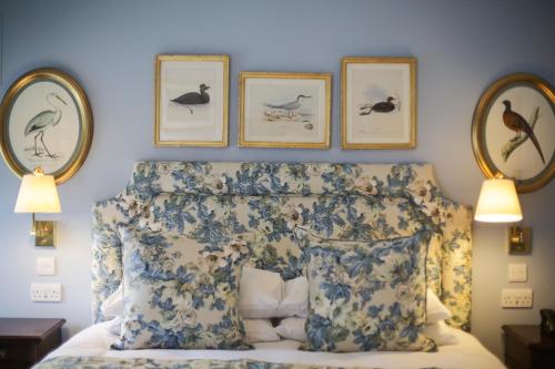 a bedroom with a bed with three pictures on the wall at The Granary Lodge Bed & Breakfast in Thurso