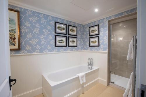 a bathroom with a tub and three pictures on the wall at The Granary Lodge Bed & Breakfast in Thurso