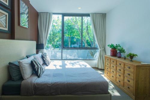 ein Schlafzimmer mit einem Bett und einem großen Fenster in der Unterkunft 2 Bedroom Khaoyai Poolsuite by Nancy in Ban Huai Sok Noi