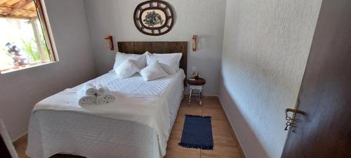 ein Schlafzimmer mit einem weißen Bett und Handtüchern darauf in der Unterkunft Casa temporada jaguaripe bahia toca do guaiamum in Jaguaripe