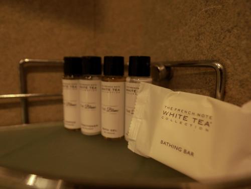 three bottles of white tea sitting on a shelf at The Greenwood, Tezpur in Tezpur