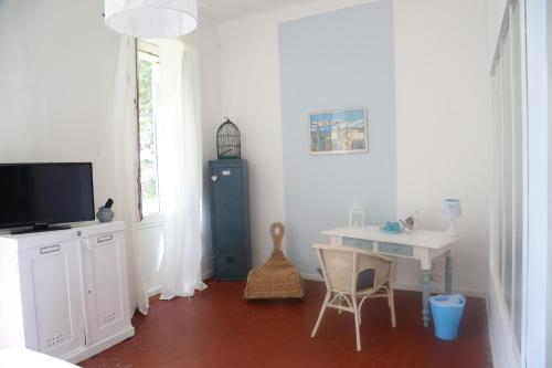 a room with a desk and a table and a tv at Maison d'Hôtes La Bastide Bleue in Marseille