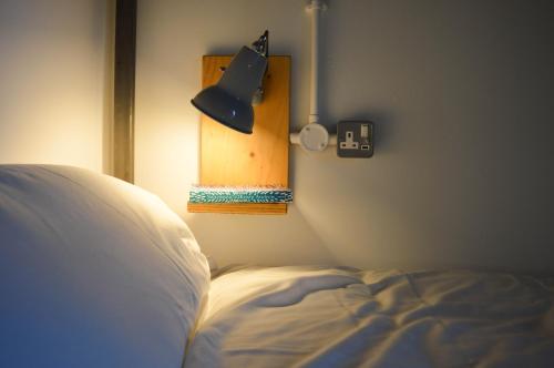 a bedroom with a bed and a lamp on a wall at The Bristol Wing in Bristol